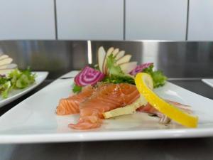 a plate of food with fish and vegetables on a counter at hôtel du commerce in Joncy