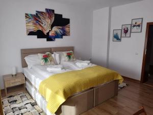 1 dormitorio con 1 cama con manta amarilla en Happy House, en Hunedoara