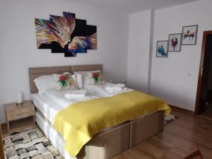 a bedroom with a bed with a yellow blanket at Happy House in Hunedoara