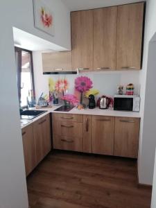 eine Küche mit Holzschränken und einer Mikrowelle in der Unterkunft Happy House in Hunedoara