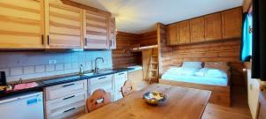 een keuken met een tafel en een bed in een kamer bij Valles Vacanze in Falcade