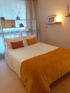 sypialnia z dużym łóżkiem i pomarańczowym kocem w obiekcie St Germain en Laye- La défense 17mn -STUDIO FIBRE -Terrasse w mieście Le Pecq