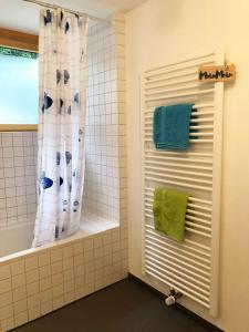 a bathroom with a shower with a window and green towels at Exklusive Ferienwohnung m. Terrasse, ruhig gelegen in Pfullingen