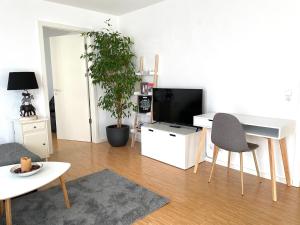 - un salon avec une télévision, une table et des chaises dans l'établissement Exklusive Ferienwohnung m. Terrasse, ruhig gelegen, à Pfullingen