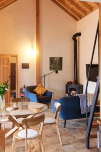 Sustainable Rural House La Lisa Dorada في Agulo: غرفة معيشة مع أريكة زرقاء وطاولات