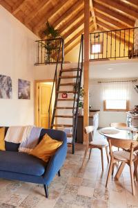 un soggiorno con divano blu e scala di Sustainable Rural House La Lisa Dorada ad Agulo
