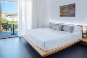 オルビアにあるFelix Hotel Olbiaのベッドルーム(白いベッド1台、バルコニー付)