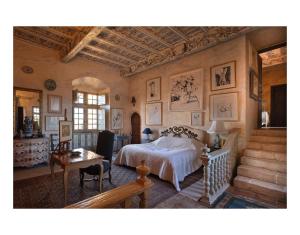een slaapkamer met een bed, een tafel en een trap bij château de Mauriac in Senouillac