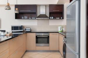 a kitchen with stainless steel appliances and brown cabinets at Icon Luxury Apartments in Cape Town