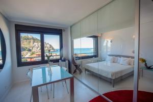 a bedroom with a bed and a table and some windows at Go Donosti Chillida in San Sebastián