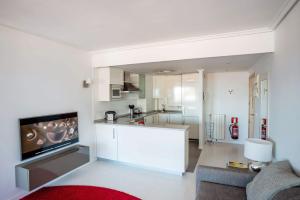 ein Wohnzimmer mit einer weißen Küche und einem Sofa in der Unterkunft Go Donosti Chillida in San Sebastián