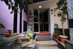 a front porch of a house with a purple wall at The Ideal Nest Kumbakonam in Kumbakonam