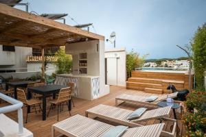 un patio avec des tables et des chaises et une cuisine dans un bâtiment dans l'établissement JUST EXPERIENCE MALLORCA, à Andratx