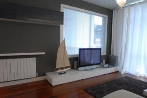 a living room with a tv and a boat on a table at Go Donosti Villa Buda in San Sebastián