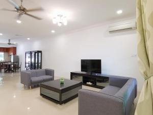 a living room with two chairs and a tv at NanSang One Homestay 8pax 4Rooms in Sibu
