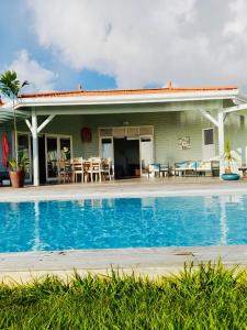 a house with a swimming pool in front of it at VILLA AQUA in Case-Pilote