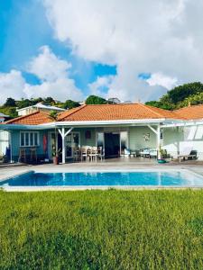 a villa with a swimming pool and a house at VILLA AQUA in Case-Pilote