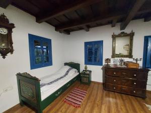 a bedroom with a bed and a dresser and a mirror at Siklód. Botond Panoráma Kulcsosház (6 fő) Botond Panoramic Chalet in Şiclod