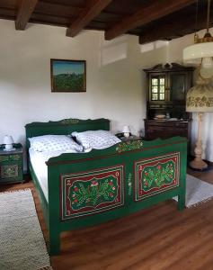 ein Schlafzimmer mit einem grünen Bett in einem Zimmer in der Unterkunft Siklód. Botond Panoráma Kulcsosház (6 fő) Botond Panoramic Chalet in Şiclod
