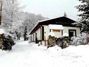 un edificio cubierto de nieve con una valla en Zbójnicki Ostęp, en Stronie Śląskie