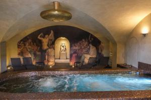 a large swimming pool in a room with a painting at Hôtel Restaurant Spa Le Sauvage in Besançon