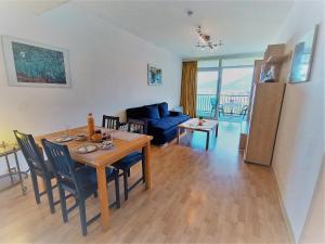 uma sala de estar com uma mesa e um sofá azul em LB1 Seeblick Appartement Haus Landskron direkt am Ossiachersee em Landskron