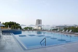 a large swimming pool with chairs and umbrellas at Status-M Apartments 85 in Bečići