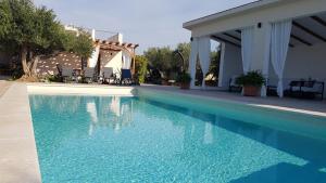 uma piscina com água azul numa casa em Stone Villa Olea - Holiday house in olive grove em Supetar
