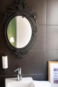 a bathroom sink with a mirror above it at Hôtel Petit Saint-Honoré in Paris