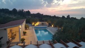 uma vista superior de uma piscina ao anoitecer em Stone Villa Olea - Holiday house in olive grove em Supetar