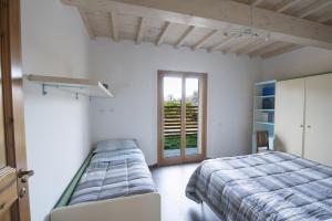 1 dormitorio con 2 camas y ventana en Il Fienile di Margherita, en Vicchio