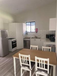 a kitchen with a wooden table and two chairs at Rural Self Contained 3 bedroom Cottage on acreage, in Landsborough