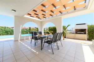 uma sala de jantar com mesa e cadeiras numa villa em Kymma Villa #16 em Agia Napa