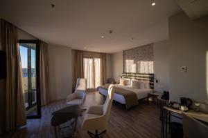 Habitación de hotel con cama, sillas y sofá en abba Sevilla, en Sevilla 37 fotos más