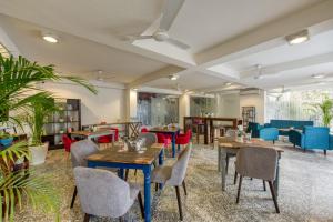 um restaurante com mesas de madeira, cadeiras e plantas em ROSASTAYS Gurugram Sec 31 em Gurgaon