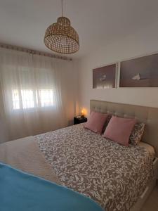 - une chambre avec un lit et 2 oreillers roses dans l'établissement Apartamento con gran terraza a 50 m de la playa, à San Luis de Sabinillas