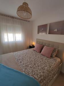 - une chambre avec un grand lit et 2 oreillers roses dans l'établissement Apartamento con gran terraza a 50 m de la playa, à San Luis de Sabinillas