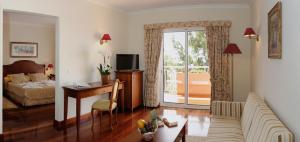 a living room with a bed and a desk with a computer at Ocean Gardens in Funchal
