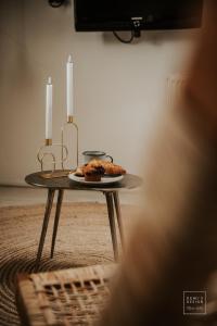 a table with two candles and a plate of food on it at Guesthouse in het Voorhuys in Doesburg