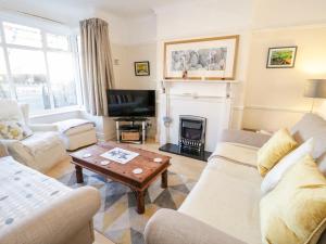 a living room with two couches and a fireplace at 91 Penrhyn Avenue in Colwyn Bay