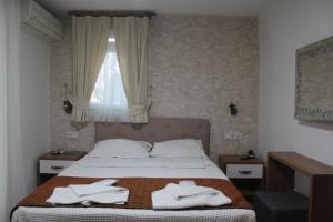 a bedroom with a bed with white towels on it at Masal Hotel in Buyukada