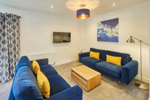a living room with a blue couch and yellow pillows at Host & Stay - West Cliff Retreat in Whitby