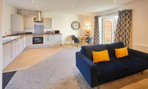 a living room with a blue couch and a kitchen at Host & Stay - West Cliff Retreat in Whitby