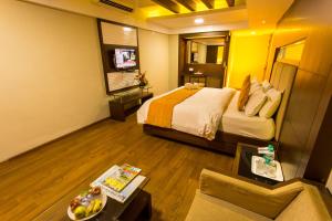 una camera d'albergo con letto e divano di The Madurai Residency a Madurai