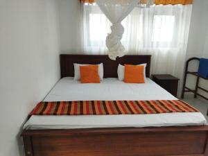 a bedroom with a large bed with orange pillows at Villa 307 3 room apartment in Matara