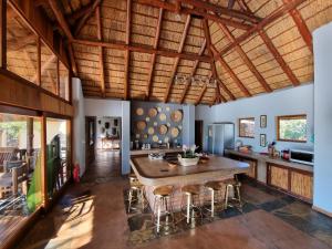 una cucina con un grande tavolo in legno e sedie di Livingstone Bush Lodge, Mabalingwe a Bela-Bela