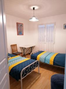 Zimmer mit 2 Betten und einem Tisch in der Unterkunft maison d'hôtes in Saint-Julien-lʼArs