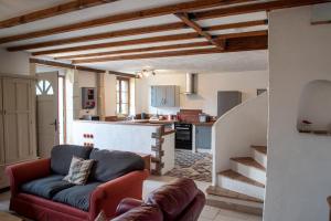 sala de estar con sofá y cocina en Lavender House - Traditional stone house oozing charm and character, en Cersay