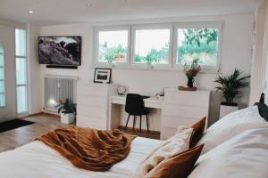 um quarto com uma cama, uma secretária e janelas em Smart-Apartment BlickWinkel Schwarzwald em Gaggenau