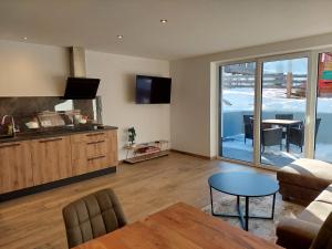 a living room with a kitchen and a table at Appartements Emilia in Ehrwald